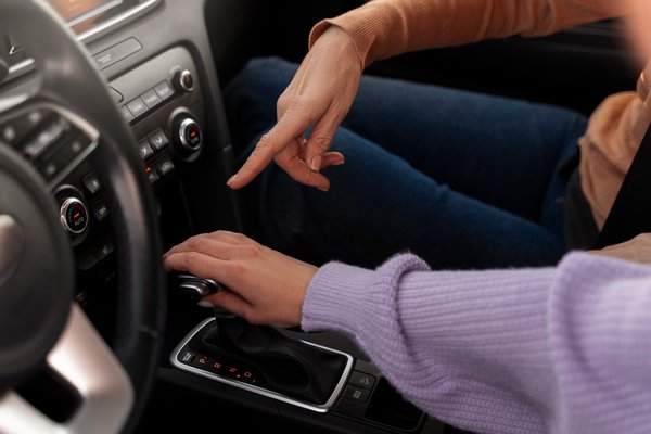 Instrutora ensinando aluna como dirigir um carro automático